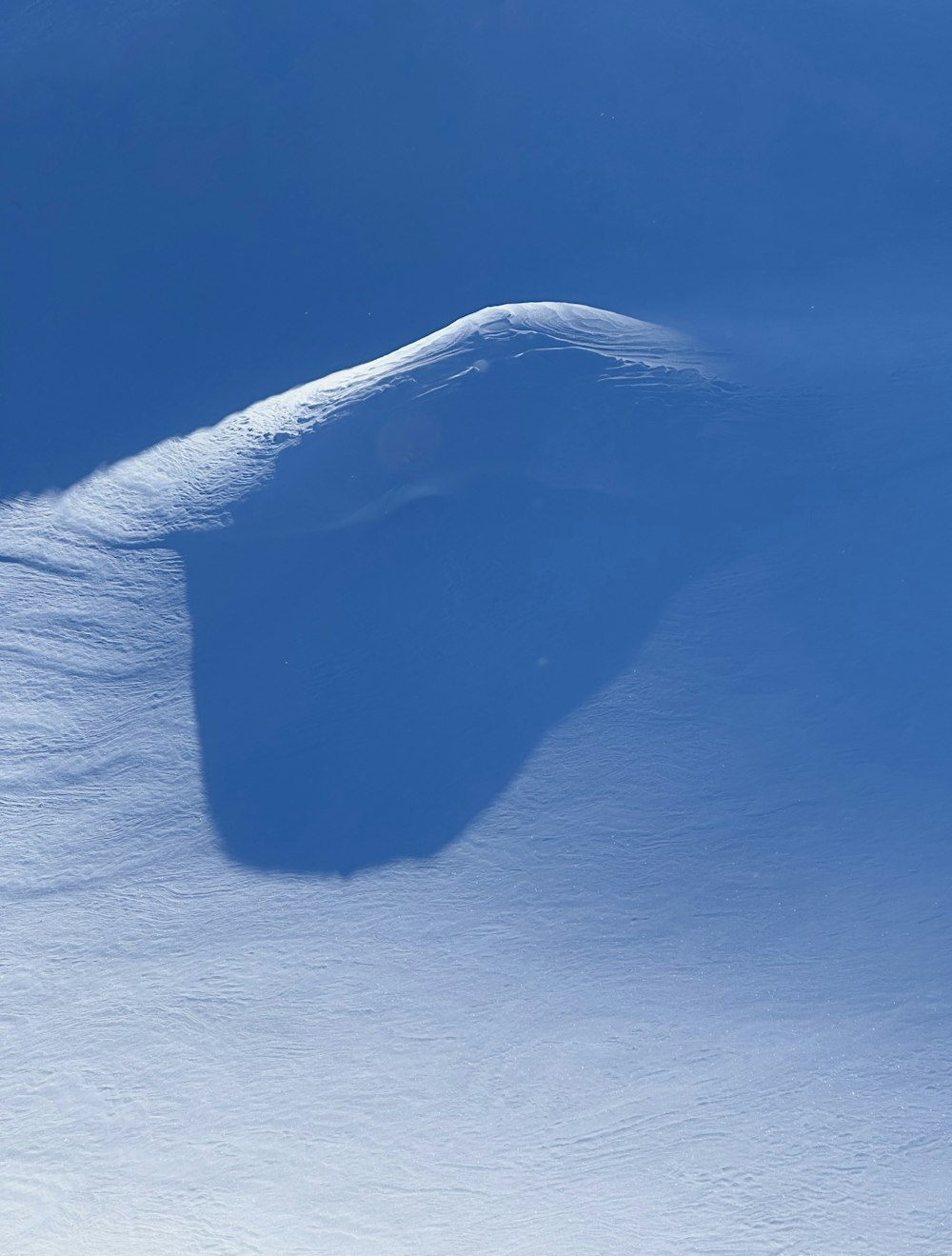 a person riding a snowboard down a snow covered slope