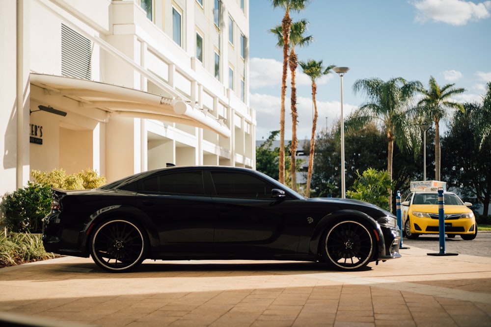 a black sports car parked in front of a hotel