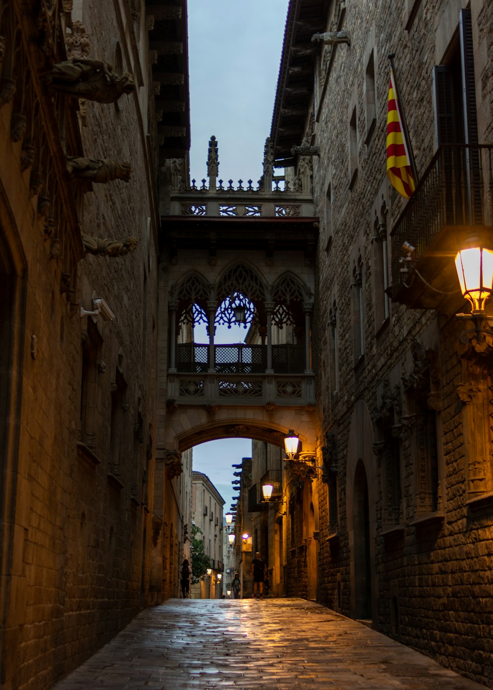 a narrow alley way with a bridge over it