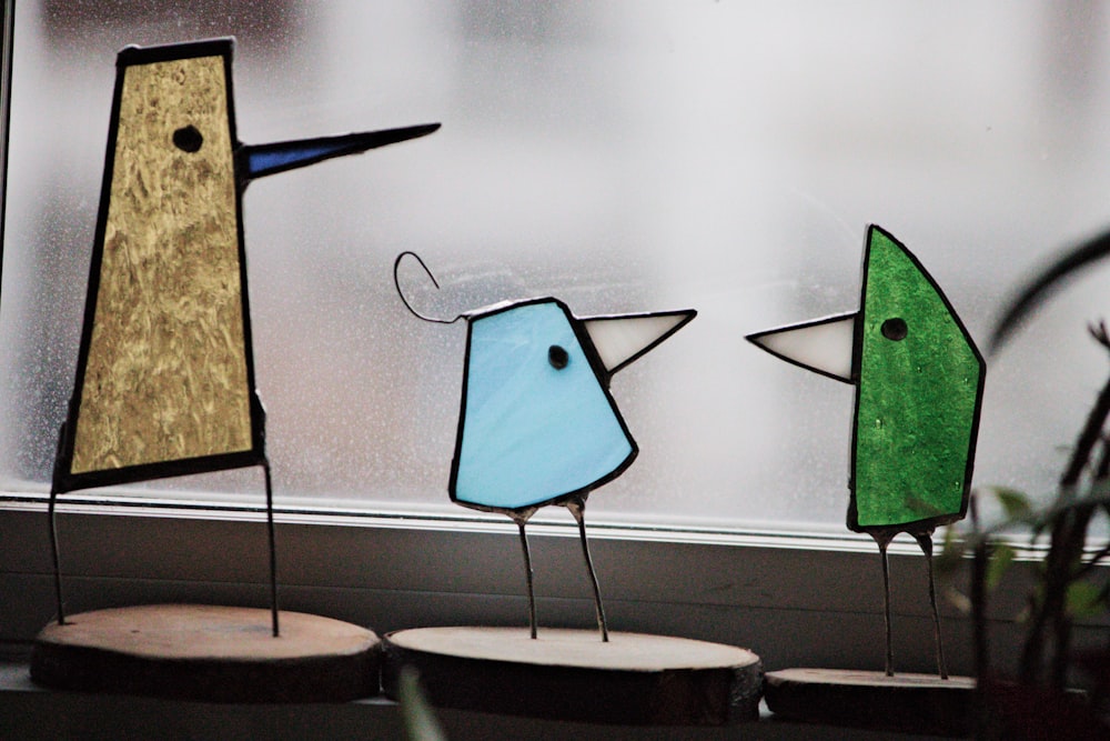 창틀 위에 앉아있는 세 마리의 새 무리