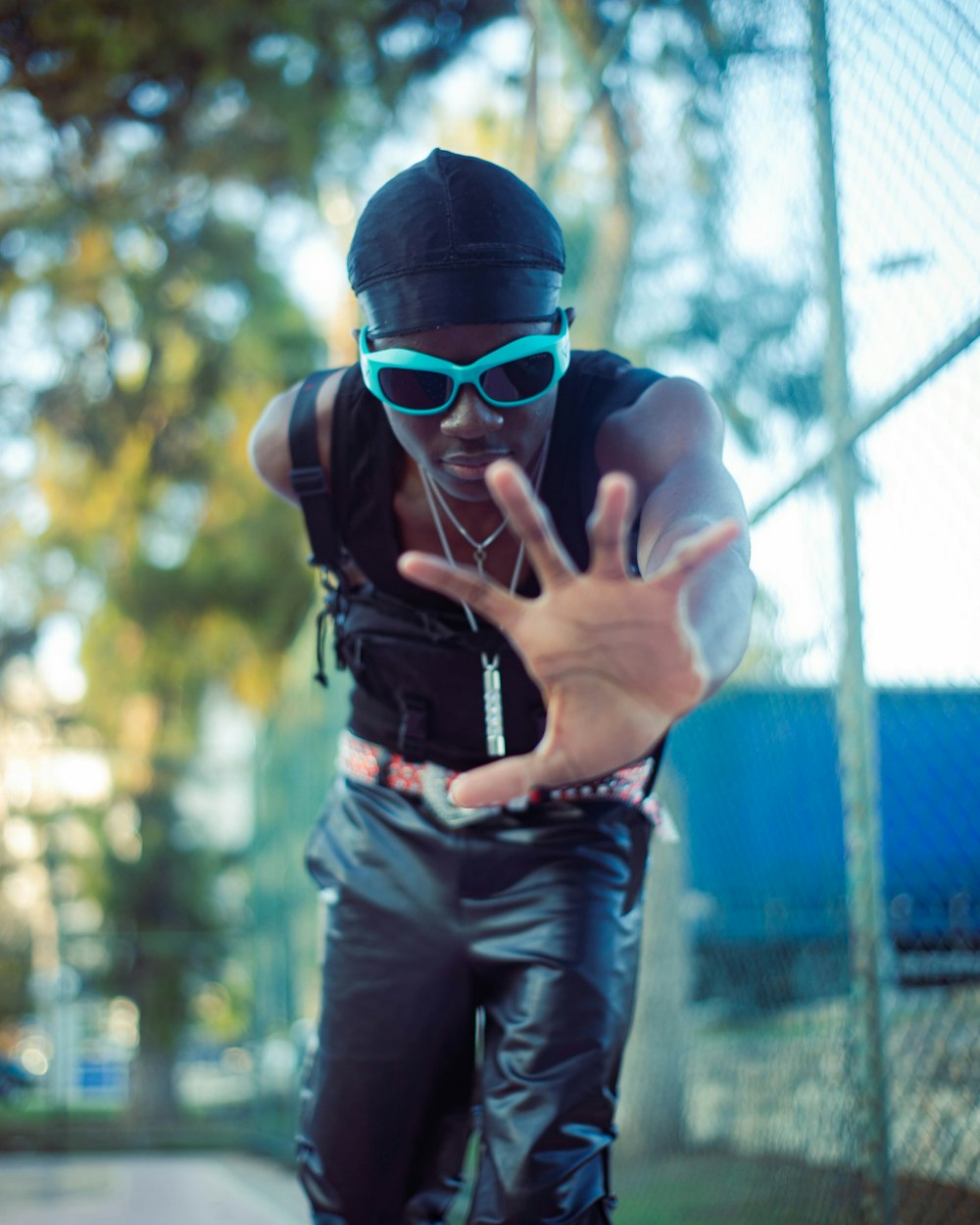 a man in black shirt and sunglasses doing a trick on a skateboard