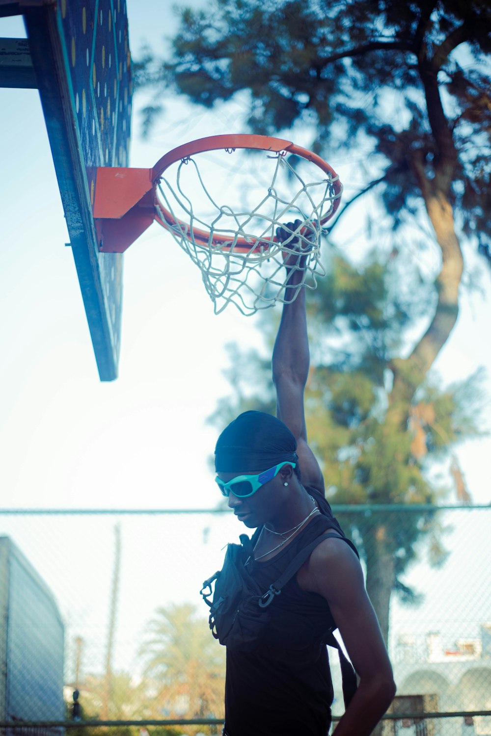 a woman is playing basketball on a sunny day