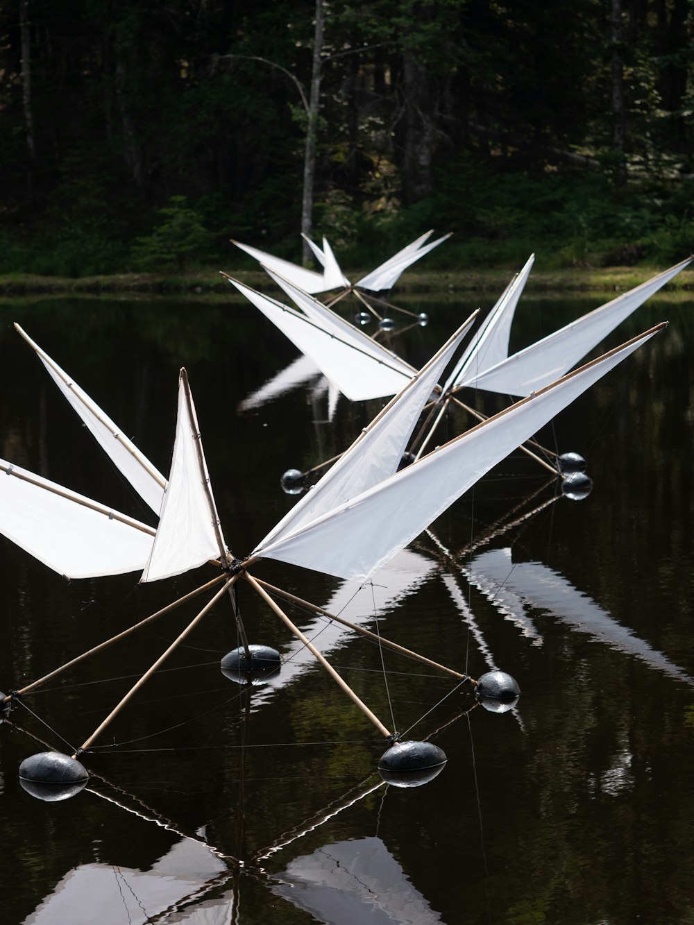 a group of paper cranes floating on top of a lake