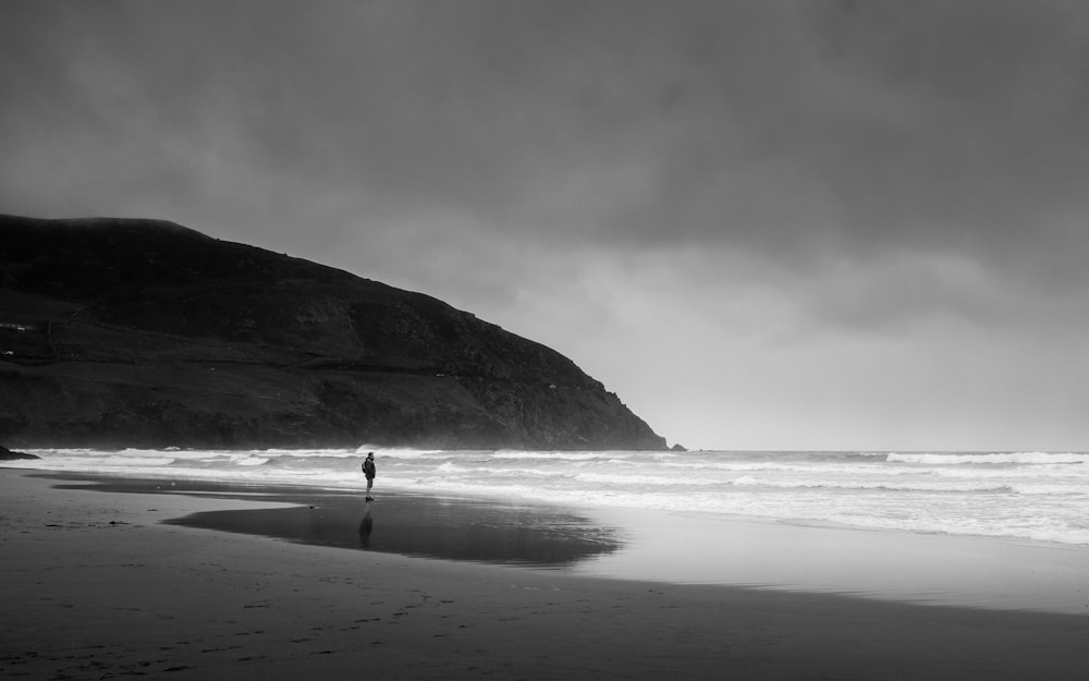 a person standing on a beach next to the ocean