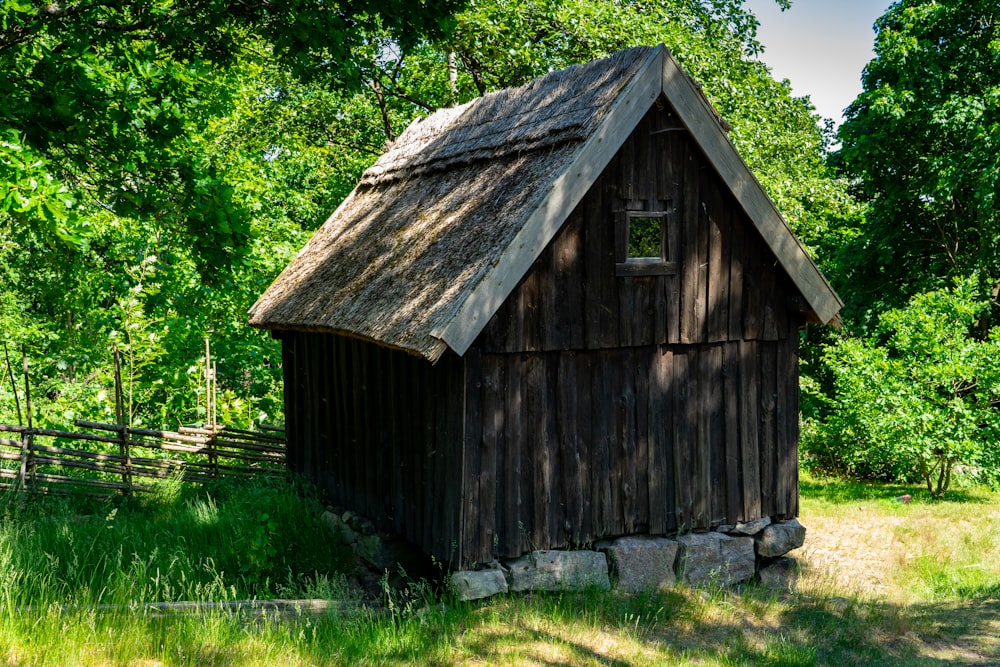un petit bâtiment en bois avec un toit de chaume
