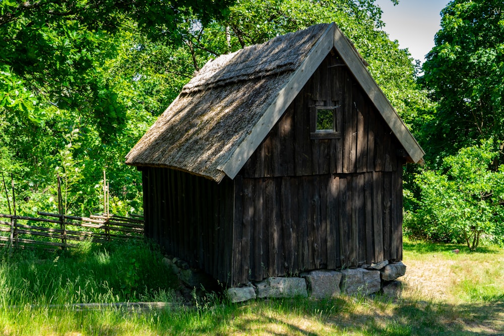 a small wooden building with a thatched roof