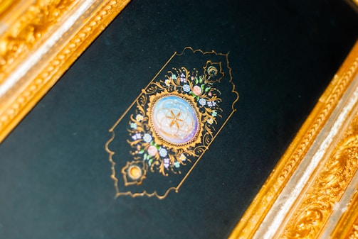 A mystical golden ornamental frame glowing softly against a deep black background.