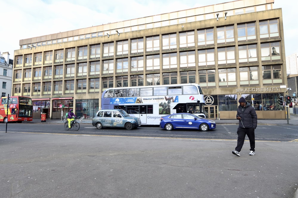 a double decker bus driving past a tall building