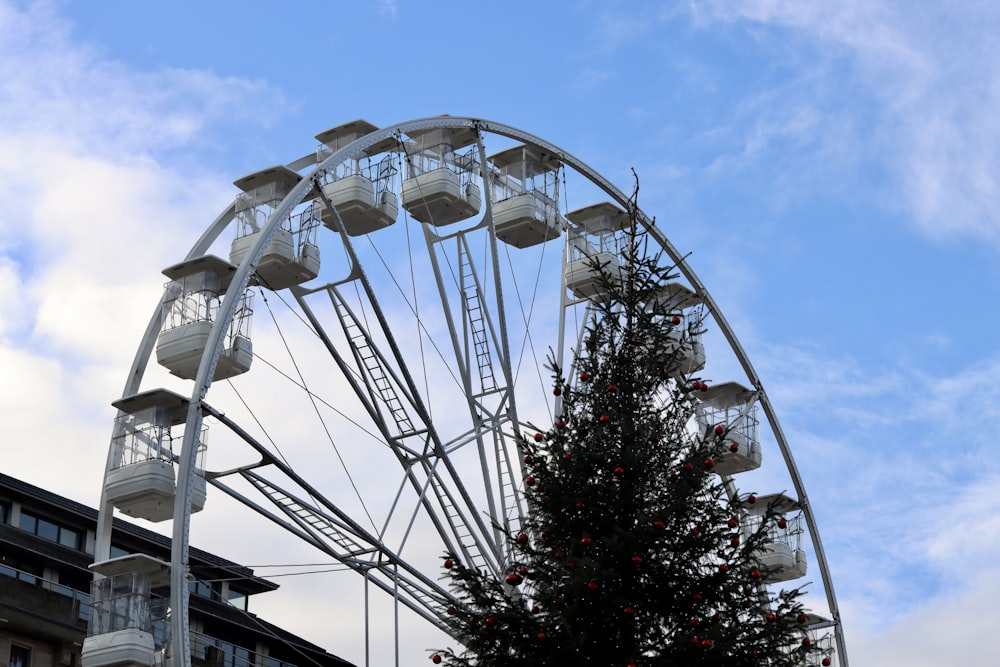 Uma roda gigante com uma árvore de Natal à sua frente