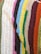 A close-up view of a crocheted fabric featuring multiple colorful stripes aligned next to each other. Each stripe is a different color, showcasing a variety of textures and thicknesses typical of crochet work.