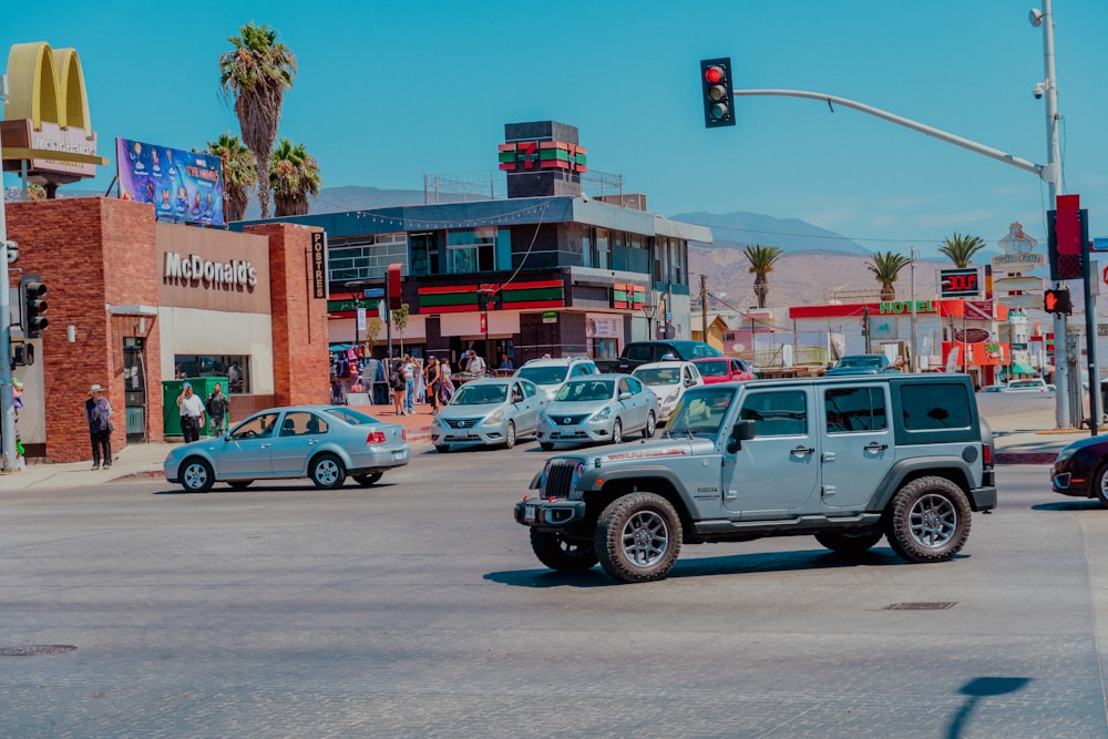 a jeep driving down a street next to a traffic light