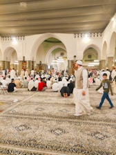 A warm, inviting synagogue interior with people engaged in prayer and study.