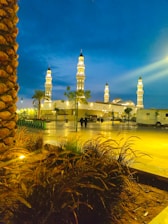 A serene mosque exterior at sunset with lanterns glowing softly.