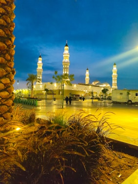 A peaceful evening view of Omar Ibn Al-Khattab mosque surrounded by community members.
