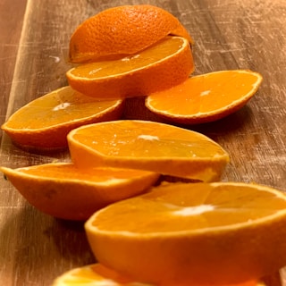 Bright orange slices arranged artfully on a wooden table, highlighting their juicy texture.