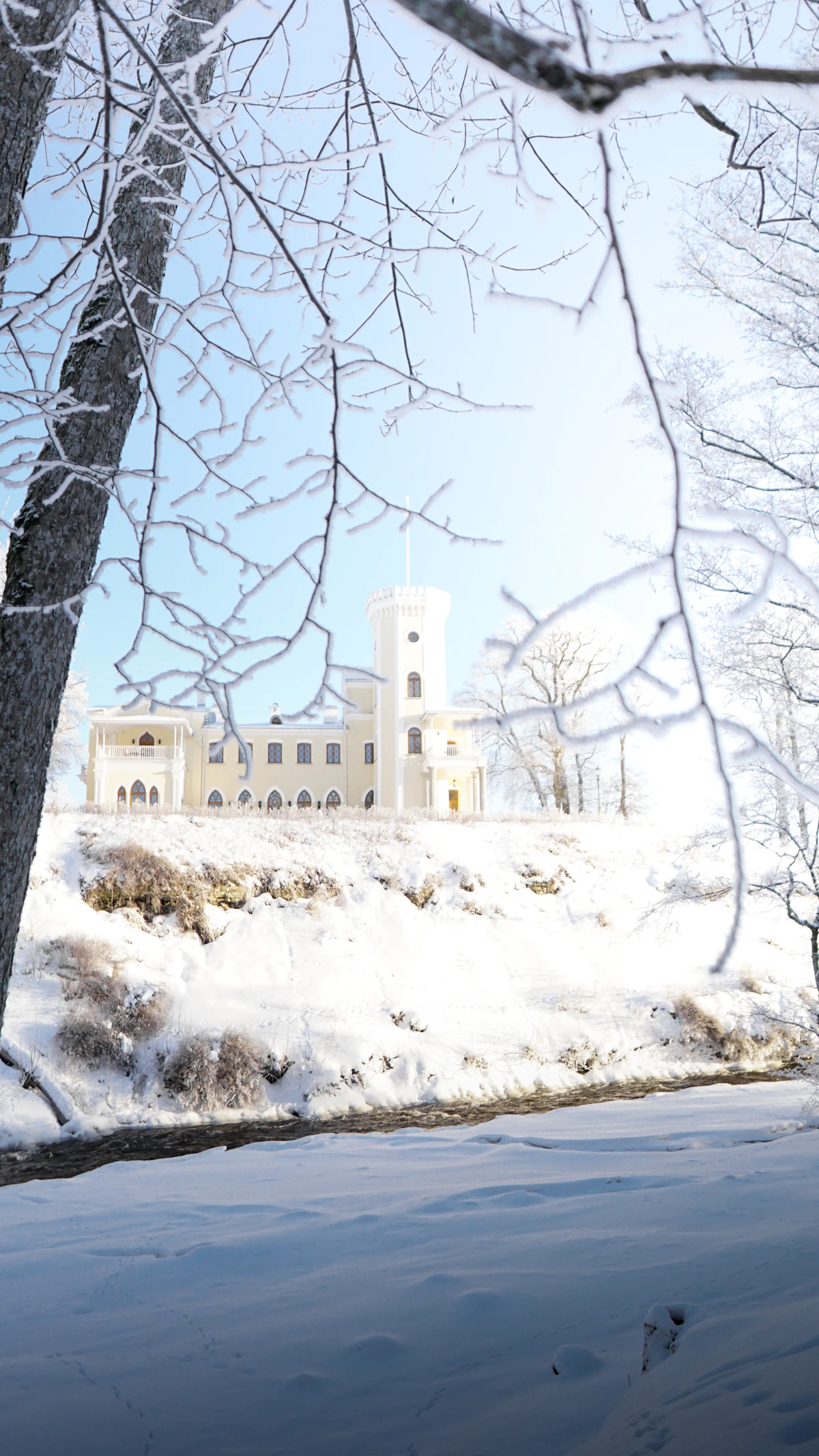 A large white building sitting on top of a snow covered hill