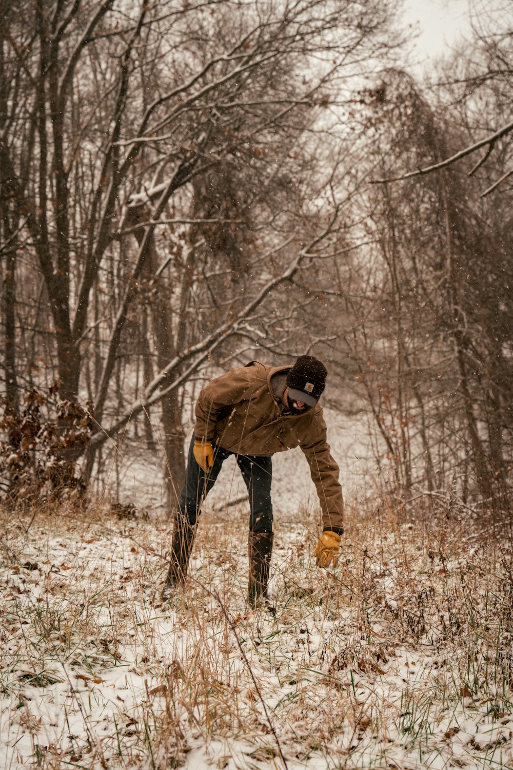 a man standing in the snow in a wooded area