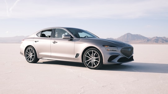 a silver car is parked in the middle of the desert