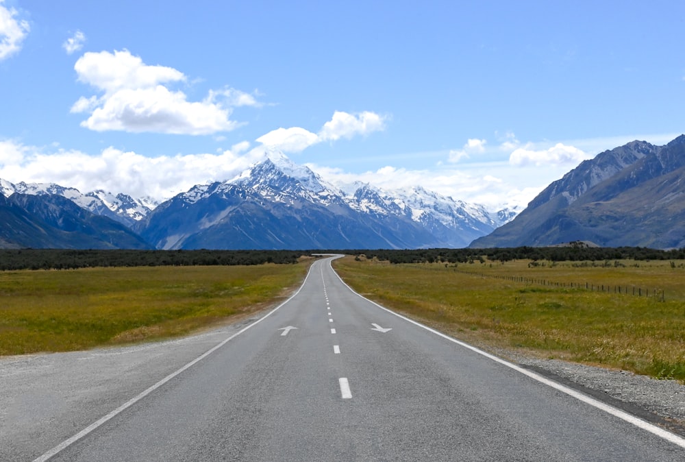 an empty road with mountains in the background