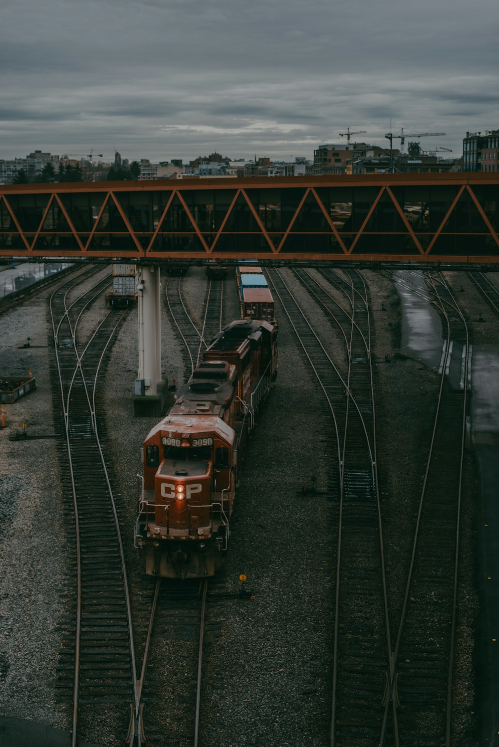 a train traveling down train tracks under a bridge