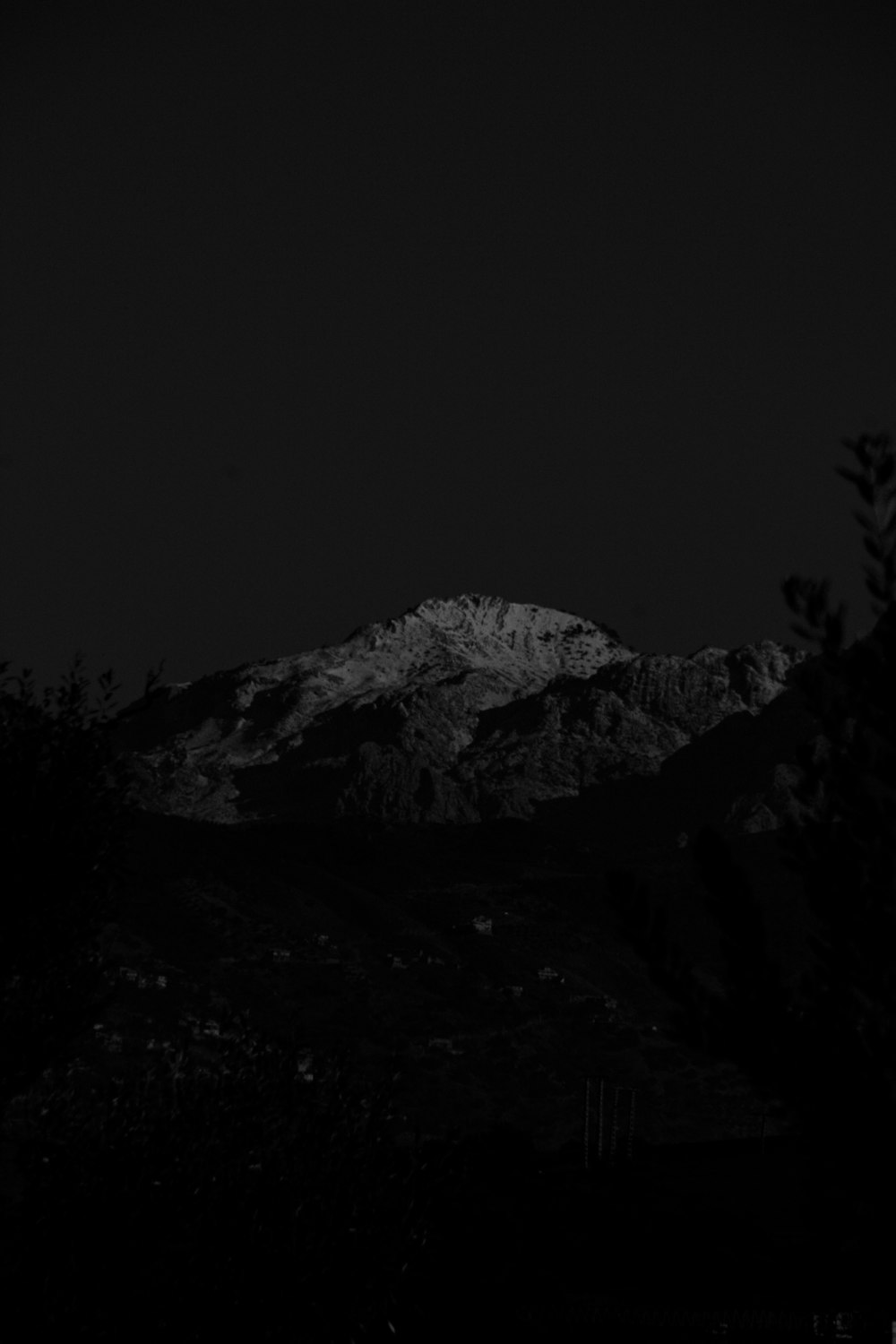 a black and white photo of a mountain at night