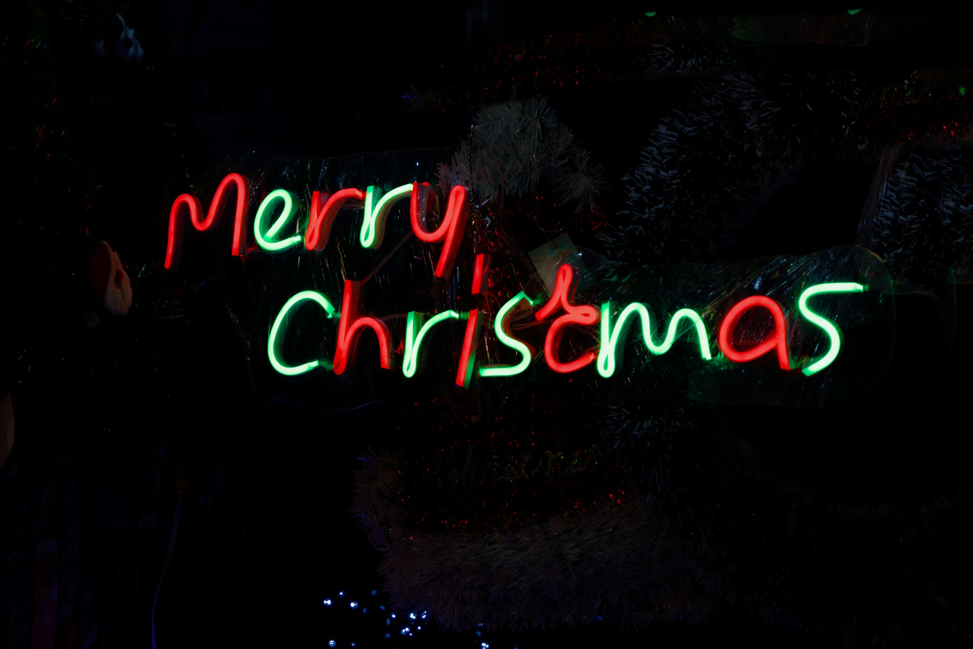a merry christmas sign lit up in the dark