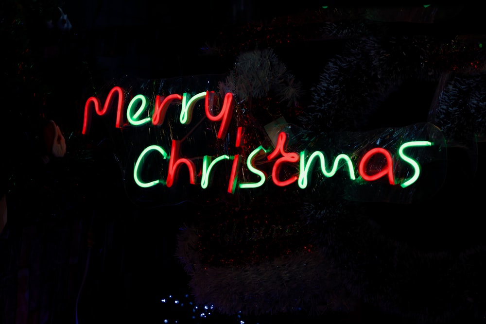 a merry christmas sign lit up in the dark