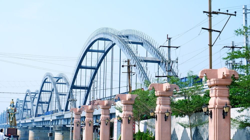 a row of pink fire hydrants in front of a bridge