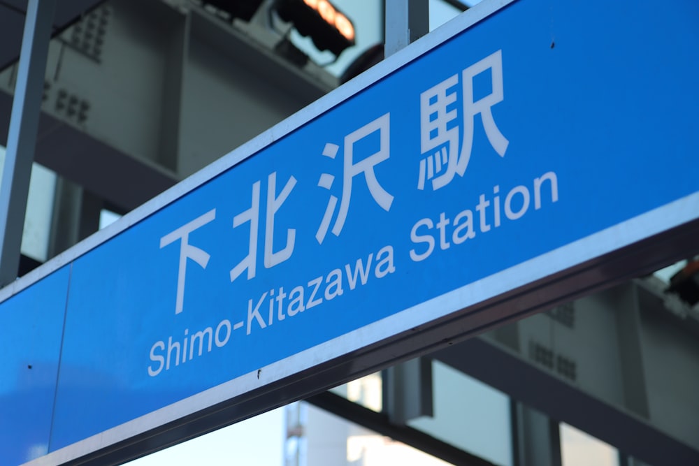 a blue and white sign that says shinno - kitazwa station