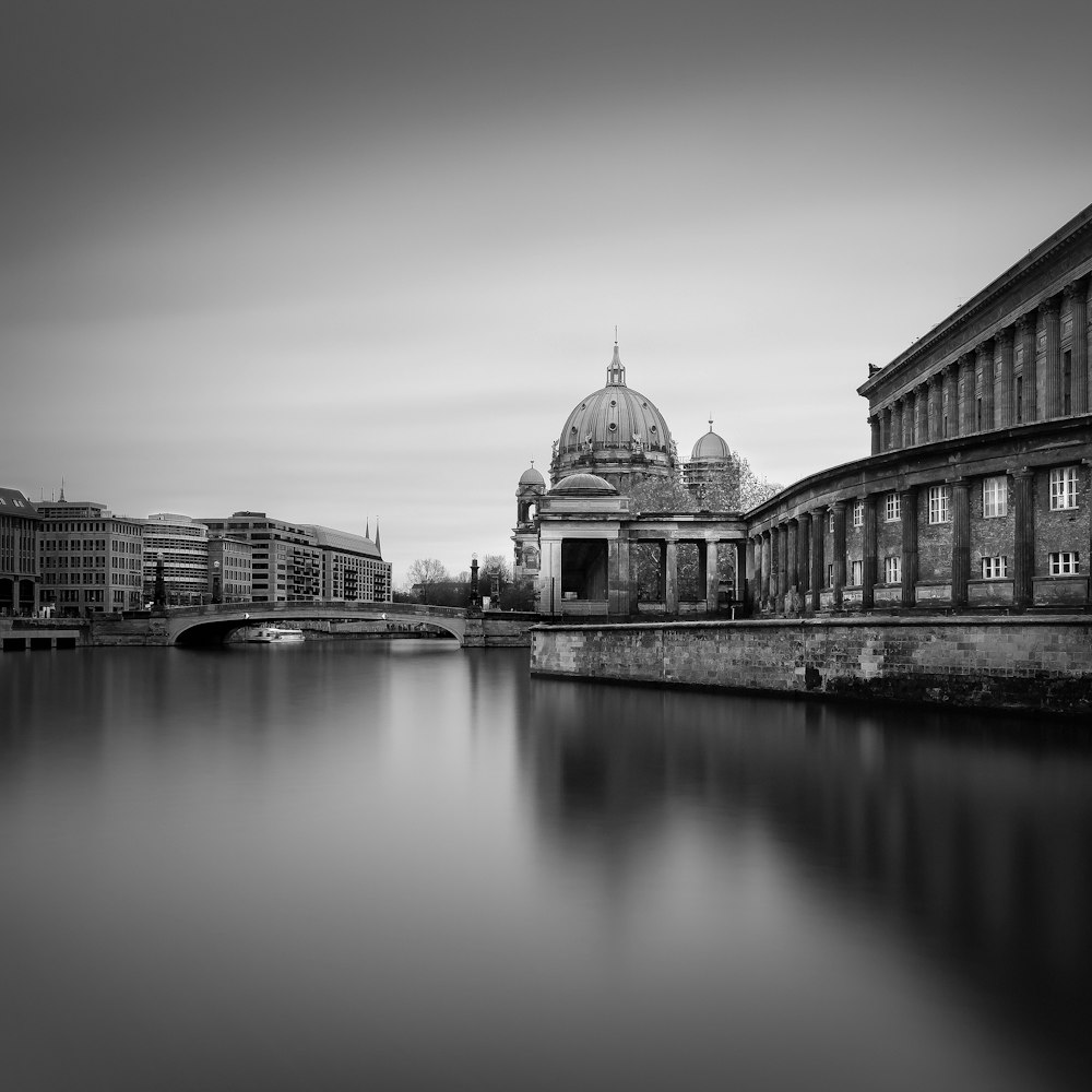 a black and white photo of a river and buildings