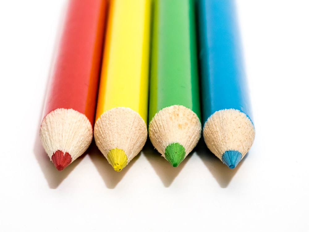 a row of colored pencils sitting next to each other