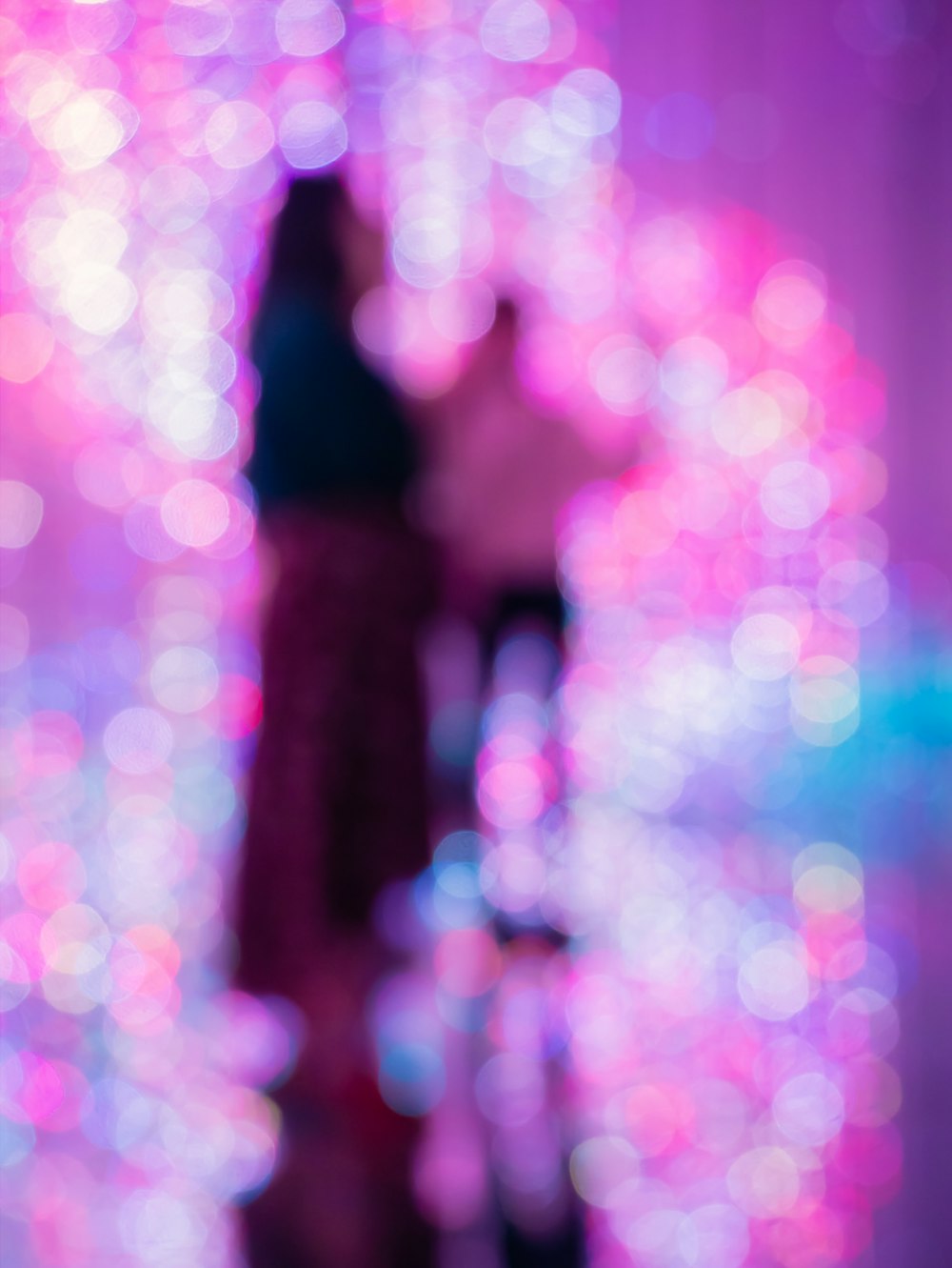 a blurry image of two people standing in front of a mirror