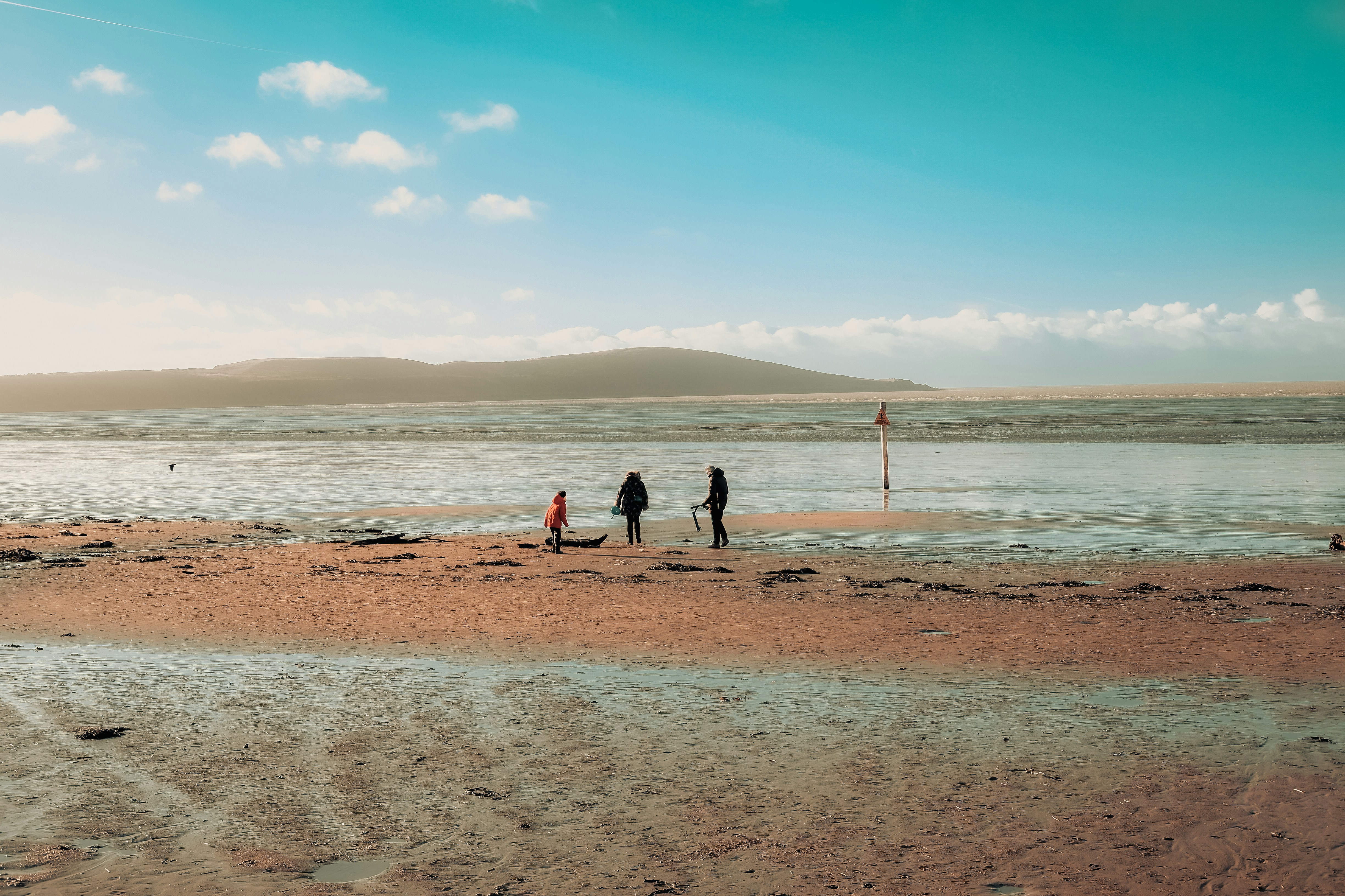 a group of people standing on top of a sandy beach