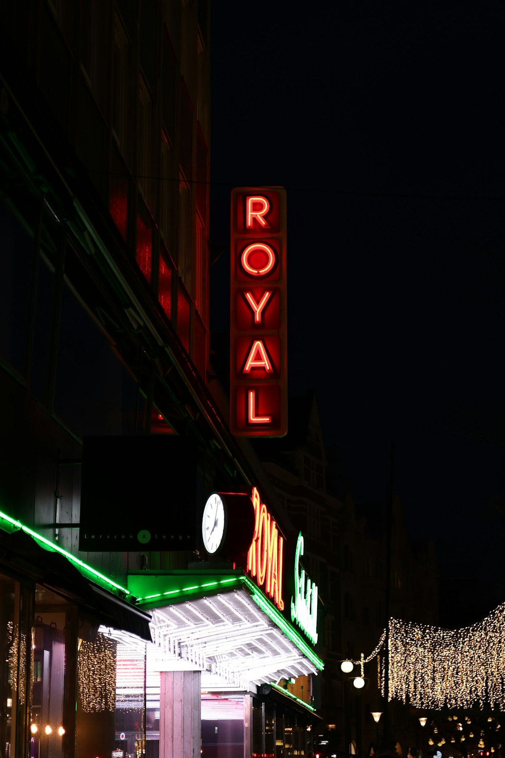 the royal hotel sign is lit up at night