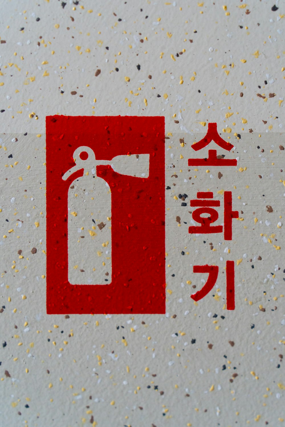 a red and white fire extinguisher on a white surface