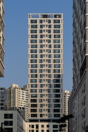 A sleek high-rise apartment building surrounded by bustling city streets in Cairo.