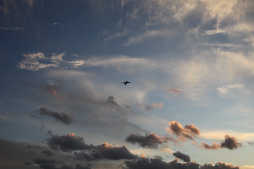 a plane flying through a cloudy blue sky