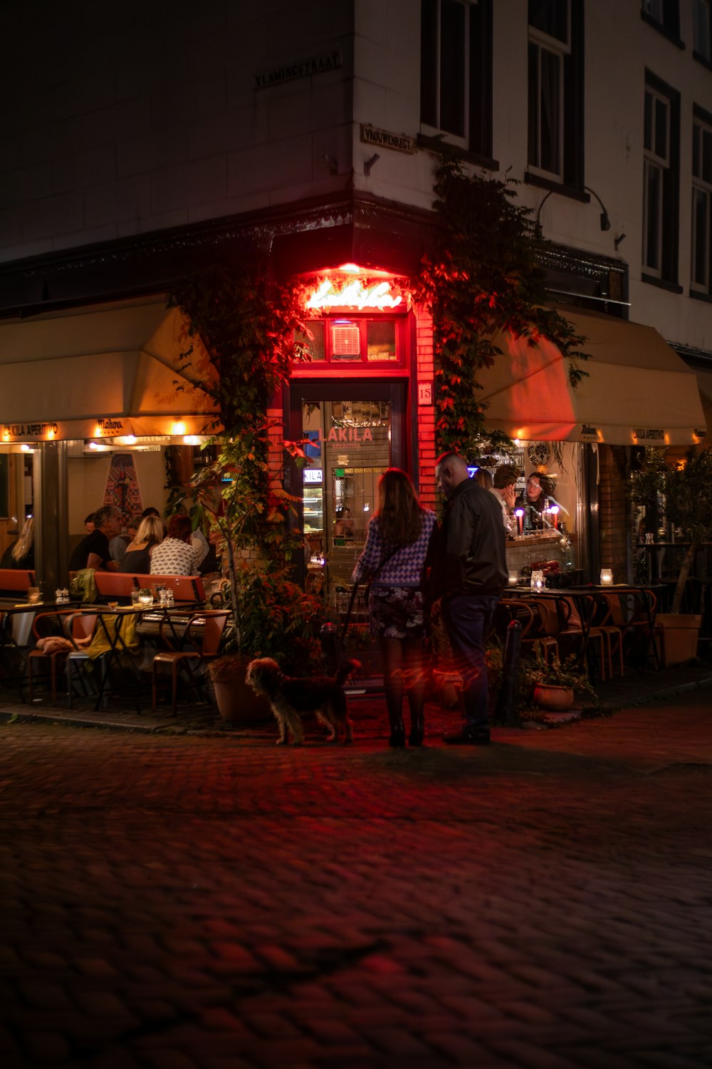 a man and a woman standing in front of a restaurant