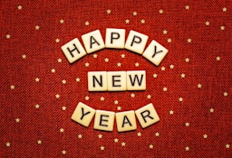 happy new year spelled with scrabbles on a red background