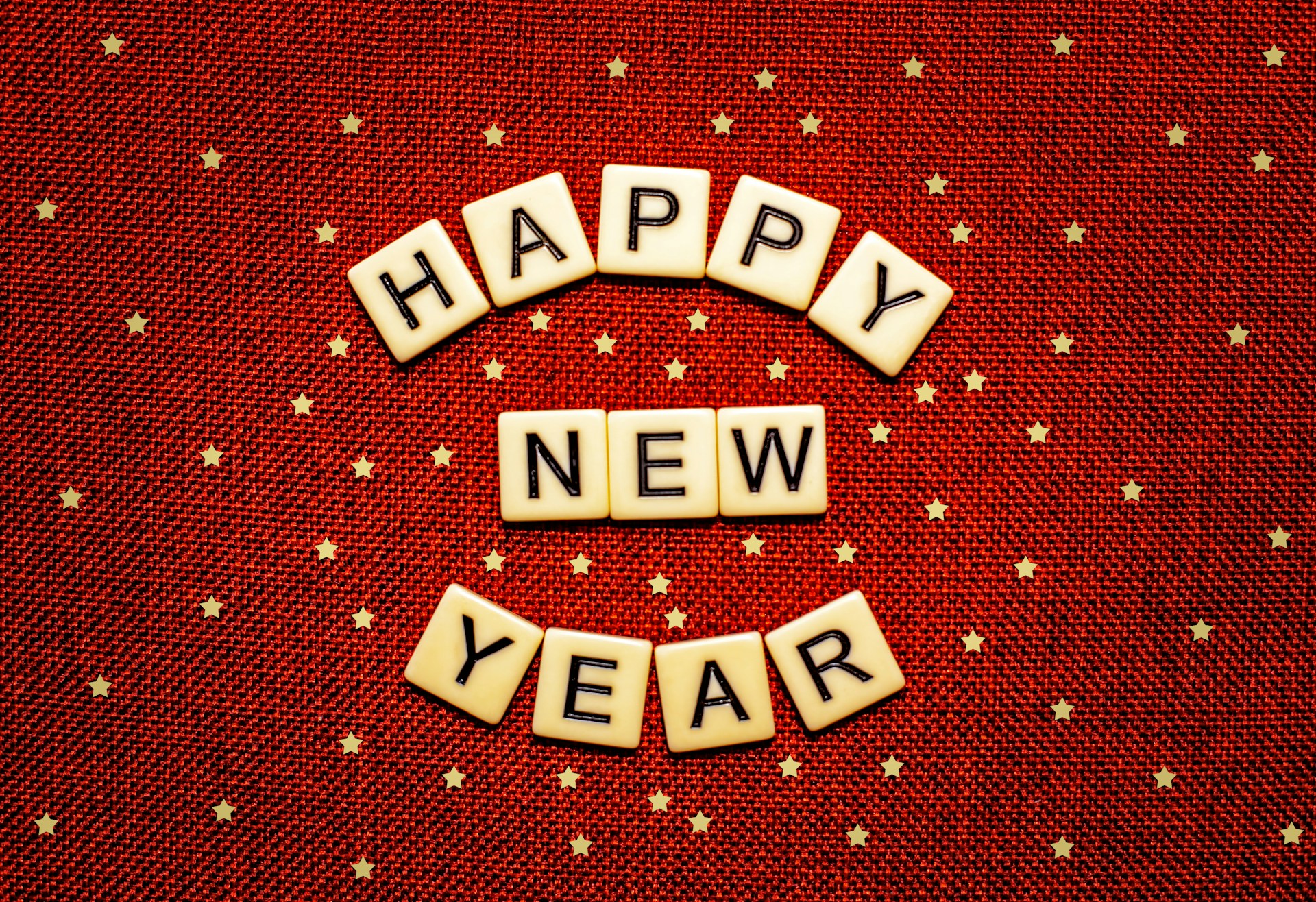 happy new year spelled with scrabbles on a red background