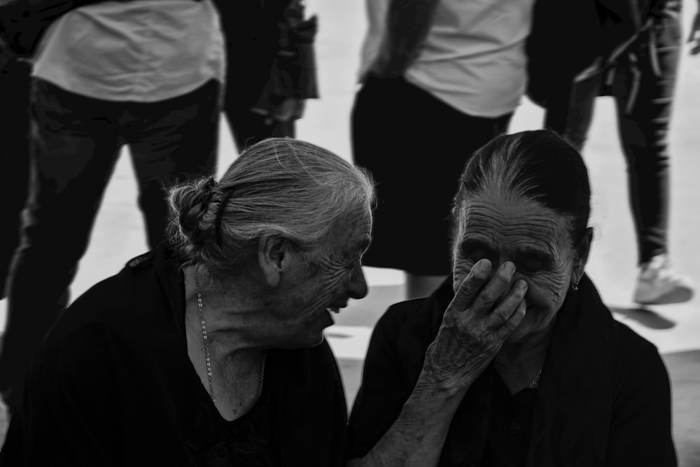 a black and white photo of a woman covering her face