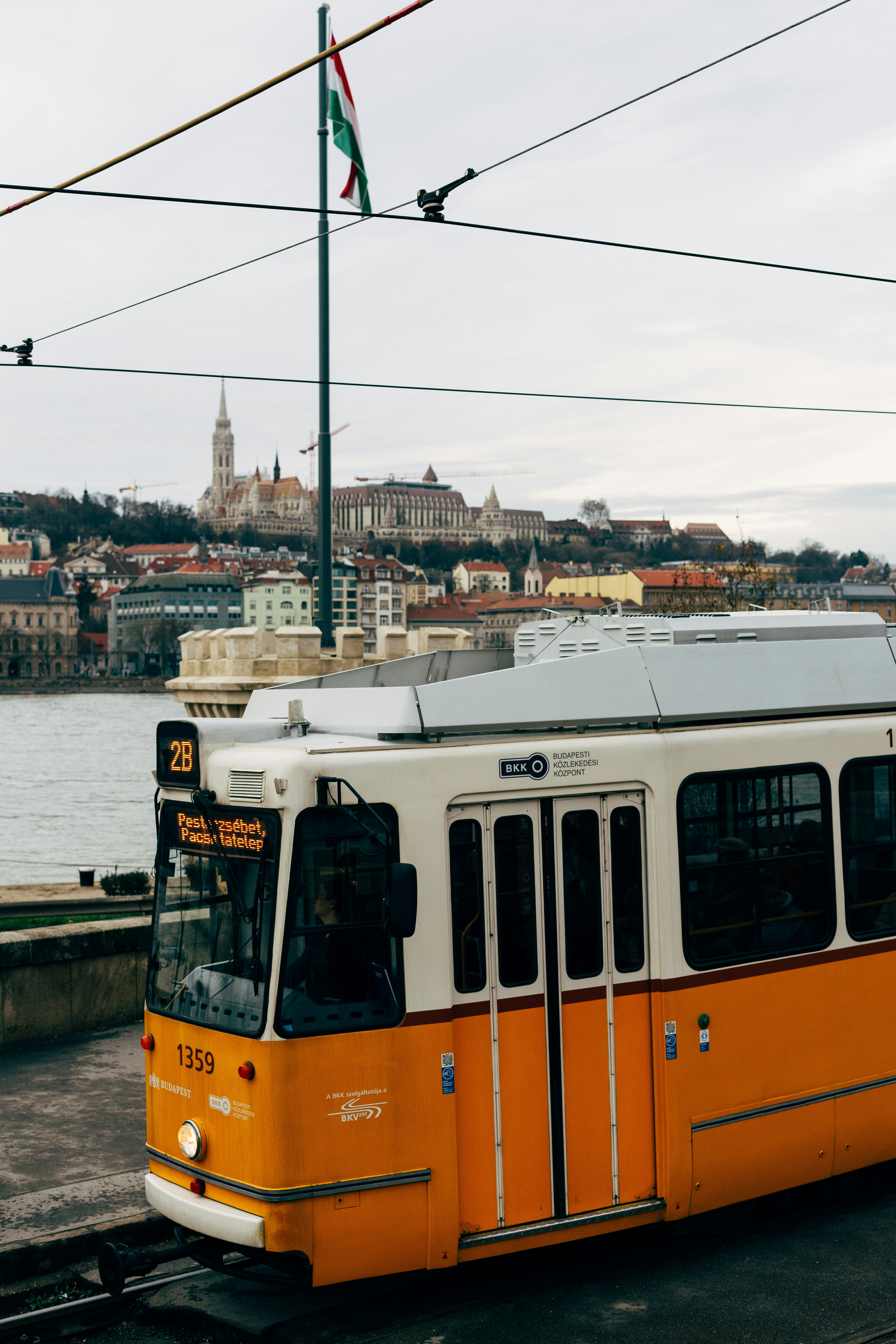 an orange and white bus parked on the side of the road
