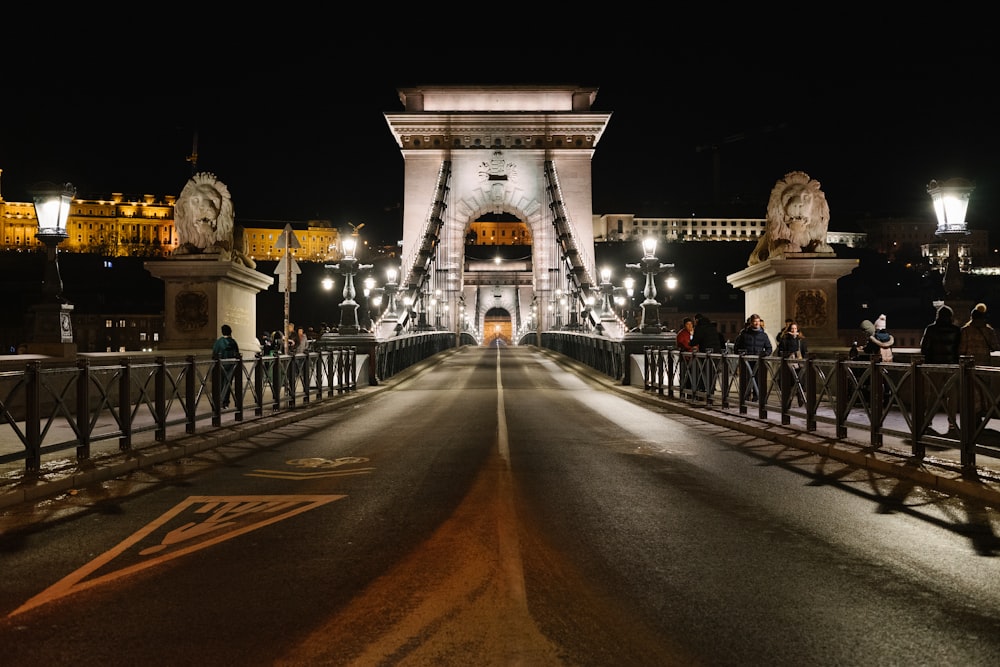 a bridge at night with people walking across it