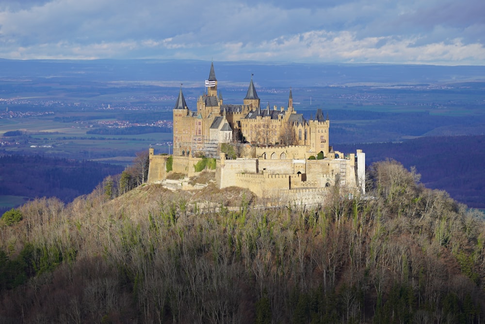 a large castle sitting on top of a lush green hillside