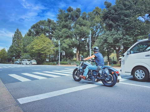 A go-jek driver waiting patiently at a busy intersection, ready to serve.