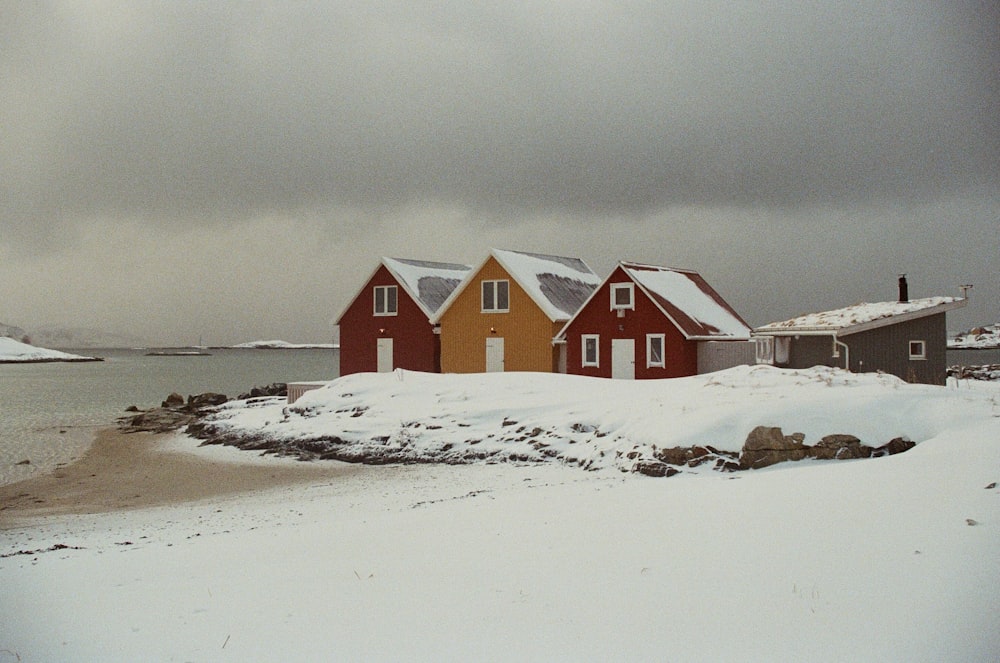 a group of houses sitting on top of a snow covered beach