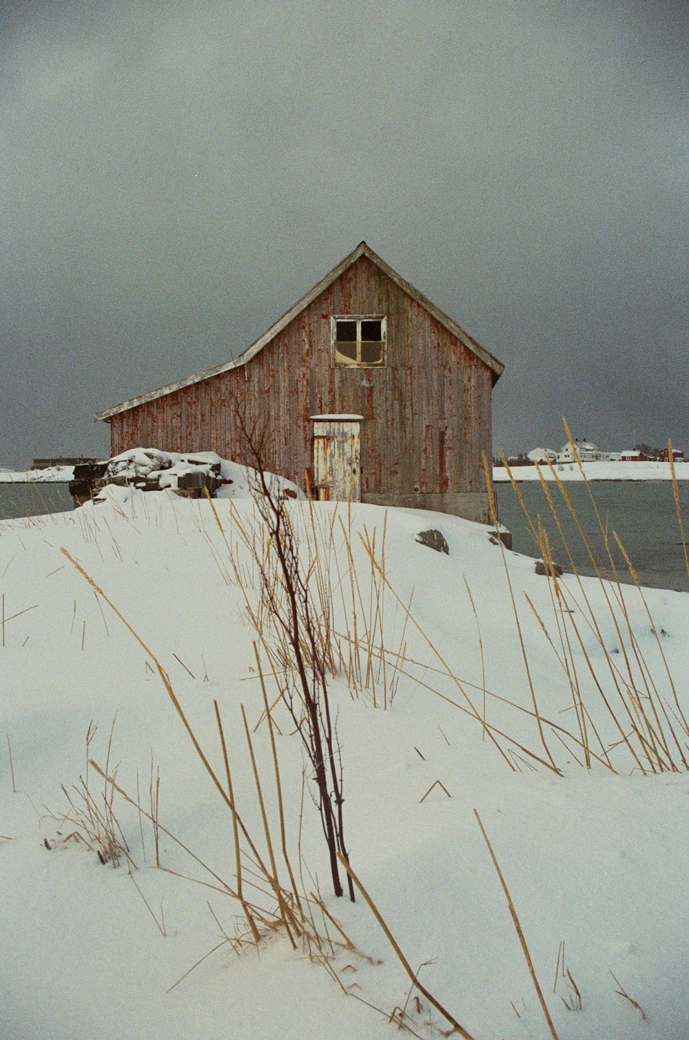 a red barn sitting on top of a snow covered field