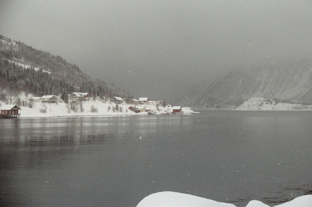 a body of water surrounded by snow covered mountains