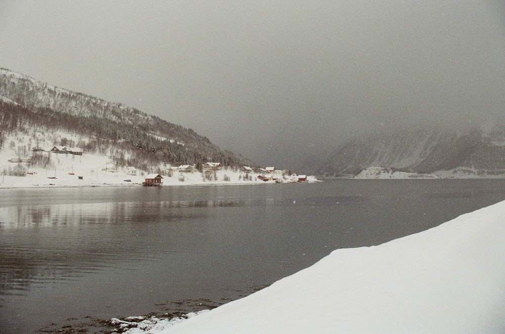 a lake surrounded by mountains covered in snow