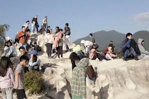 A group of local residents gathered outdoors discussing land management plans under a clear blue sky.